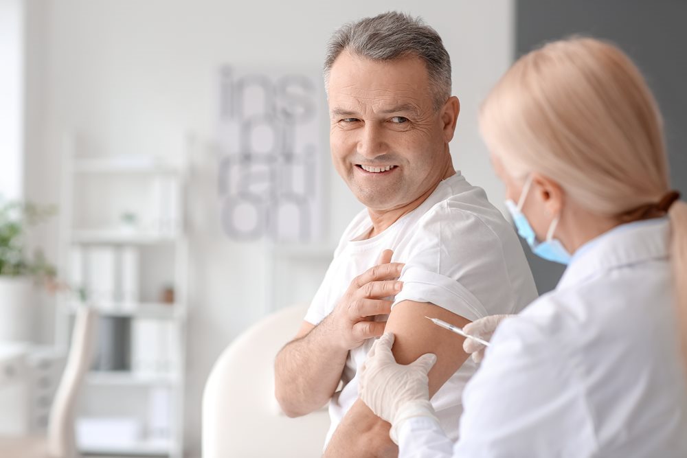 Woman provider giving man a shot in the arm