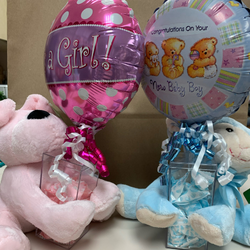 image of pink and blue stuffed animal bears holding small balloons